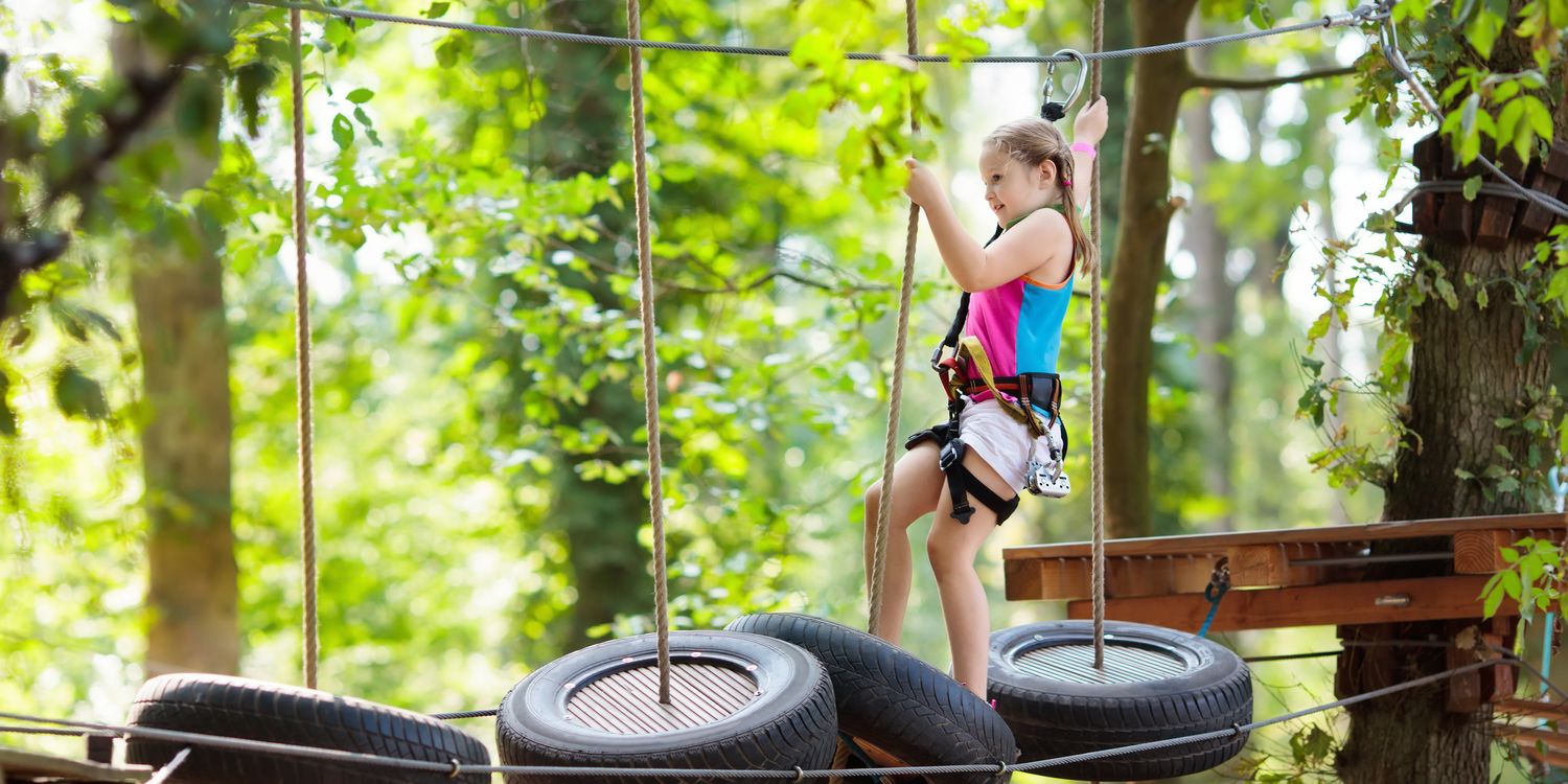 Sportlich durch den Schultag Junge Schülerin klettert im Hochseilgarten