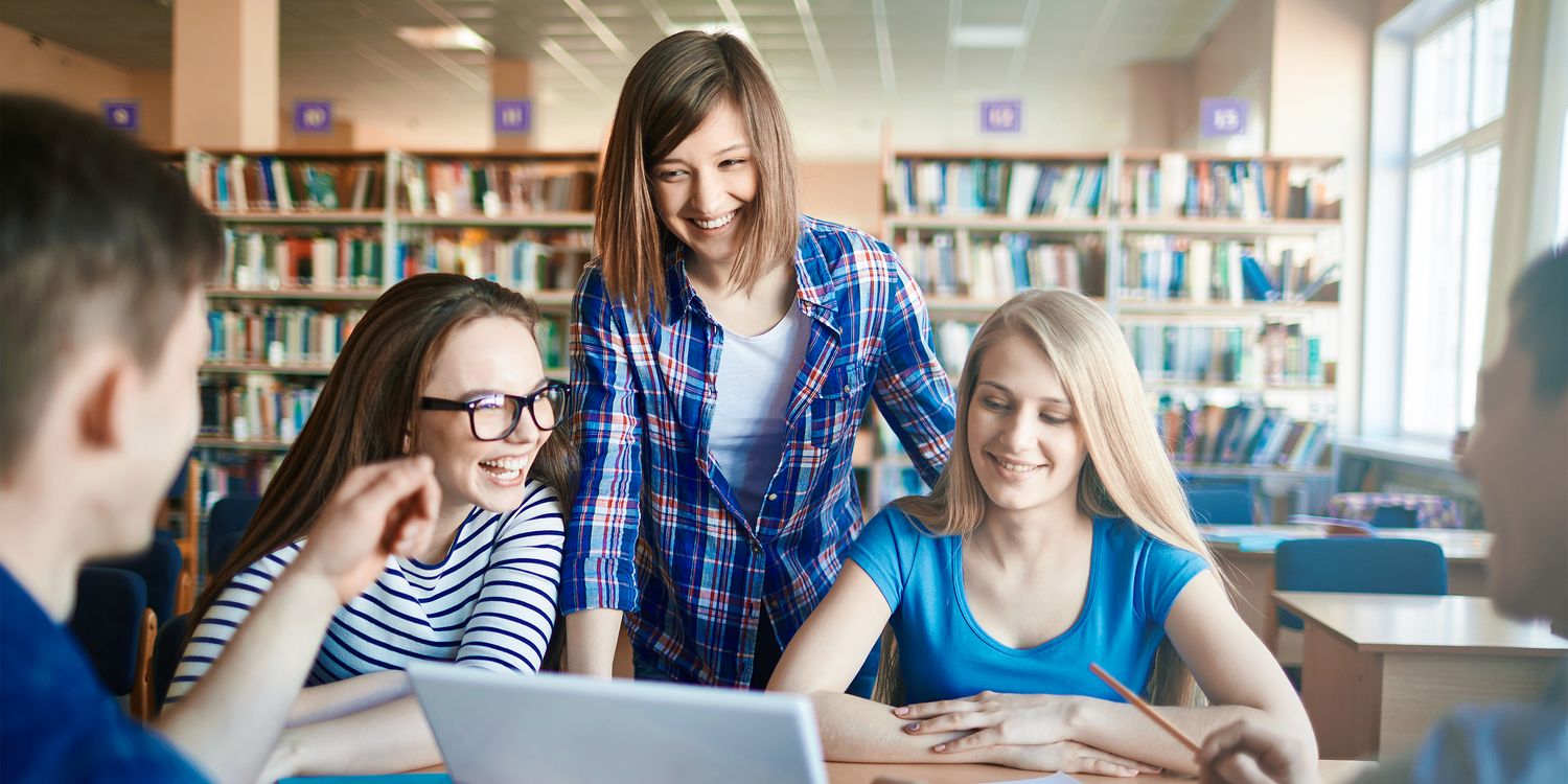 Schüler helfen Schülern Gruppe von Schüler arbeitet und lacht in Bibliothek